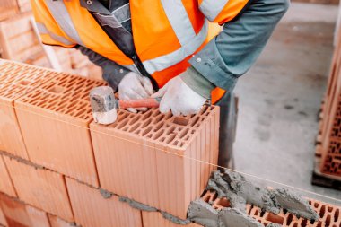 Ev inşaatı, tuğla duvar inşaatı mala, çimento ve harçla. Profesyonel inşaat işçisi çalışıyor.