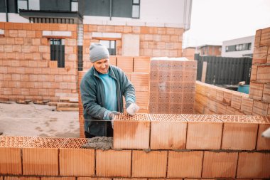 Endüstriyel detaylar - Duvarları tuğla, harç ve plastik çekiçle ören inşaat işçisi