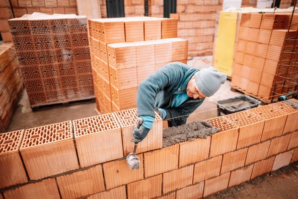 专业工人用砖和石工的详细资料建造房屋墙壁 建筑工地人员 行业详情 — 图库照片