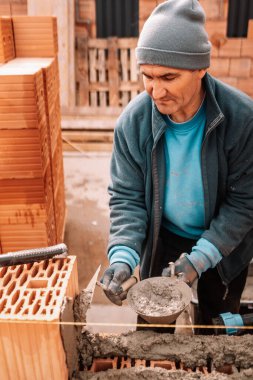 Duvarlar inşa eden endüstri işçisi
