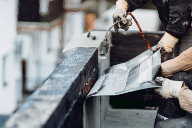Su geçirmez ev inşaatı yapan profesyonel işçiler. İşçi zarları yuvarlanıyor