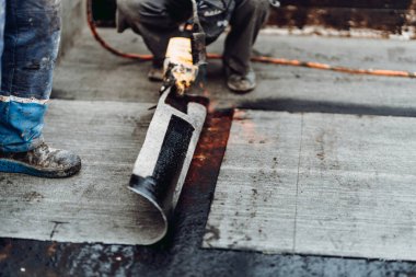 Su geçirmez yalıtım ve zar zarı sistemi. Profesyonel işçiler su geçirmez ev inşaatında oturur.