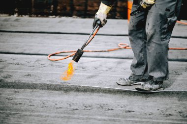 Çatı malzemesi kenarlarını ön ısıtma. Çalışma çatı onarım. Çatı malzemesi ısıtılması. Yükleme Isıtma ve asfalt erime alır. su yalıtımı