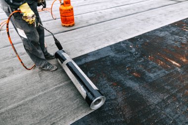 İşçiler kaynak makinesiyle zarı su geçirmez yalıtım sistemi kuruyorlar