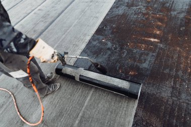 İşçiler kaynak makinesiyle zarı su geçirmez yalıtım sistemi kuruyorlar