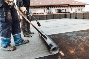 Bituminous membranlı su geçirmez sistem detayları ve çatıda kurulum. Profesyonel inşaat işçisi, su geçirmez ev inşaatı yapıyor.. 