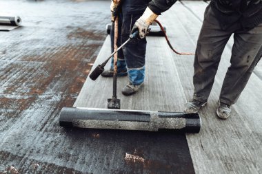 Çatı su geçirmez detayları. İşçiler zarı su geçirmez yalıtım sistemi kuruyorlar