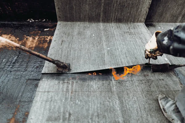 İnşaat işçileri, çatı ustaları yeni evin su geçirmez hale getirilmesi için su geçirmez zar döşüyorlar. Ev su yalıtımı ve yalıtımı