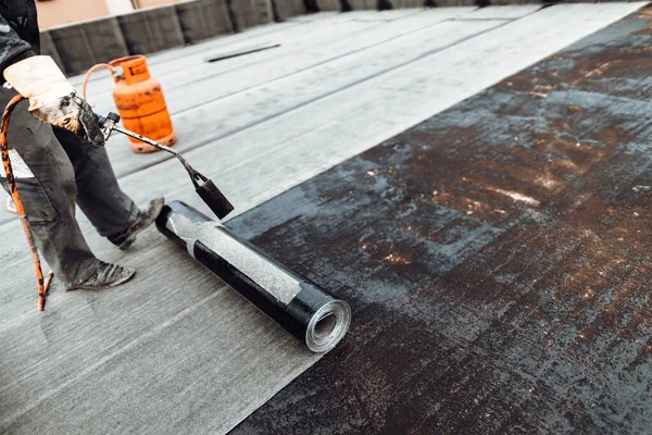 İşçiler kaynak makinesiyle zarı su geçirmez yalıtım sistemi kuruyorlar