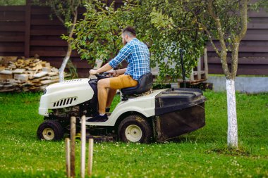 Çim biçme makinesi kullanan bahçıvan portresi. profesyonel bahçıvanlık detayları