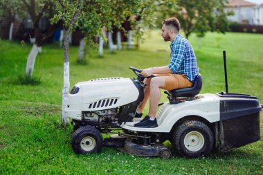 Çim biçme makinesi kullanan bahçıvan portresi. profesyonel bahçıvanlık detayları