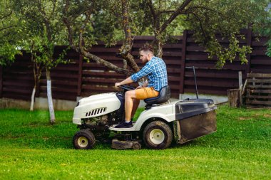 Çim biçme makinesi kullanan bahçıvan portresi. profesyonel bahçıvanlık detayları