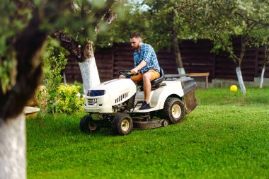 Çim biçme makinesi kullanan bahçıvan portresi. profesyonel bahçıvanlık detayları