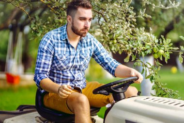 Çim biçme makinesi kullanan bahçıvan portresi. profesyonel bahçıvanlık detayları