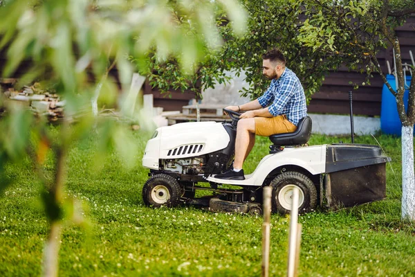 Portrait of industrial worker using lawn mower for cutting grass