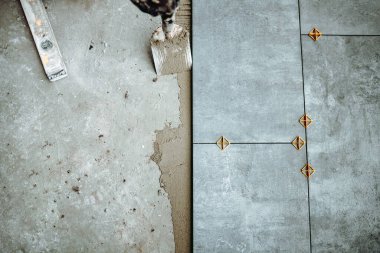 İnşaat ve yenileme işleri. Seramik fayans işçisinin fayansları yapıştırıcıya yerleştirme detayları