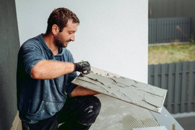 Seramik Döşeme yenileme detayları. Tiler seramik fayans yerleştiriliyor. Fayans seviyelendirme sistemi ile yapıştırıcının üzerine.