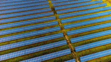 Fotovoltaik enerji santrali üzerindeki güneş panellerinin havadan görünüşü, alternatif elektrik kaynağı - sürdürülebilir kaynaklar kavramı