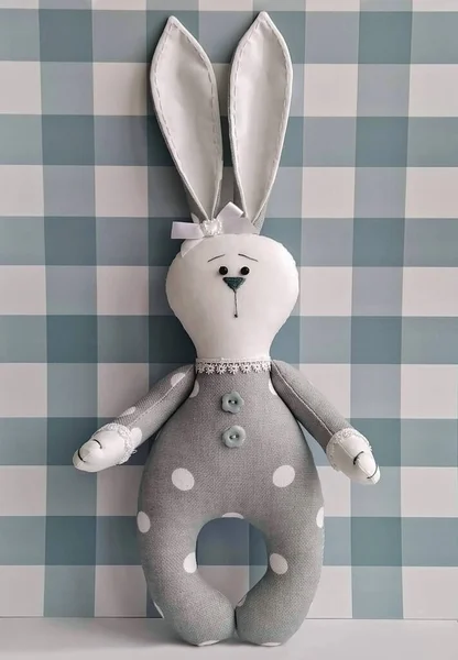 Easter bunny textile toy by handmade on checkered. Decorative soft toy, DIY