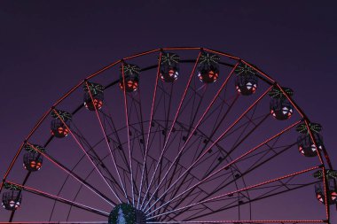 Güneşin batışına karşı çok renkli dönme dolap. Soyut kentsel mimari, hareket bulanıklığı, seçici odaklanma