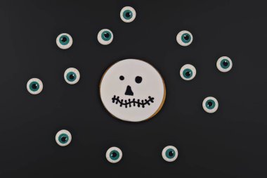 Jack Skellington 'ın tuhaf el yapımı kurabiye suratlı, siyah arka planda kocaman gözleri olan hali. Cadılar Bayramı süslemeleri ve ikramlar