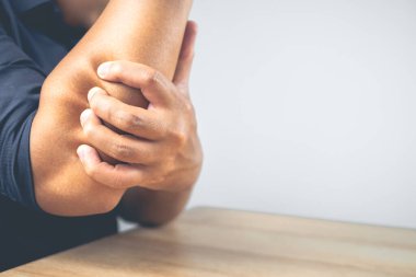 Adam dirseğini acıtıyor. Bu semptomlar spordan kaynaklanabilir. Kol ile sıkı çalışma. Kopyalama alanı ile yakın çekim.