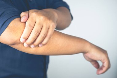 Adam dirseğini acıtıyor. Bu semptomlar spordan kaynaklanabilir. Kol ile sıkı çalışma. Yakın çekim..