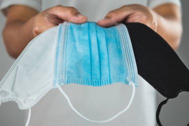 Tıbbi konsept. Hastalık koruması için birine maske vermek. Grip, grip, Covid, toz pm2.5 gibi. Bu yakın çekim maske üzerine odaklanmış. Metin, resim veya illüstrasyon için alanı kopyala.