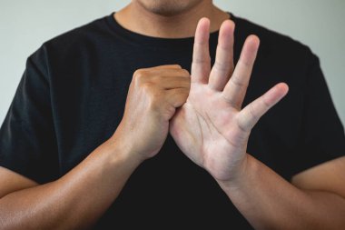 Ofis sendromu konsepti. Başparmak masaj yaptırır ve işten sonra gerilir. Yakın çekim, mavi arkaplanda izole edilmiş. Ön taraf..