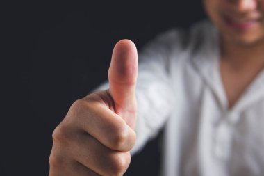 O beyaz gömlekte işaret işareti var. Maaşlı adam ya da işadamı gülümser. Ya da iyi bir kavram. Kopyalama alanı ile yakın çekim.