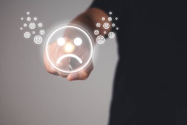 Değerlendirme ve tatmin kavramı. Elin işaret parmağı, kaşlarını çatma duygusunu gösterir. Gri arkaplanda yakın çekim.