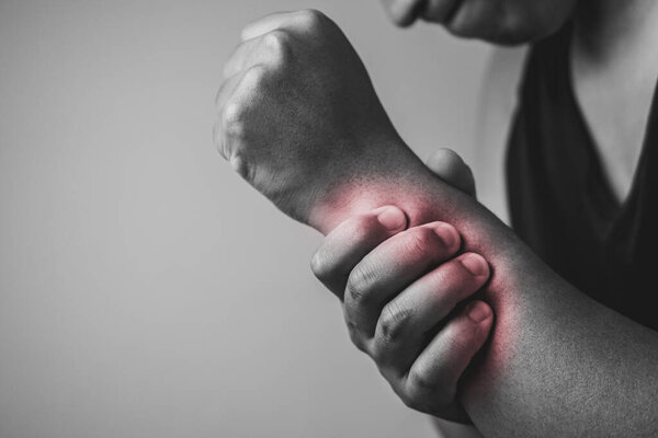 Травма локтя от тенниса и гольфа. Мужчина использует пальцы, чтобы массировать руку. Область симптомов боли показана красным цветом. Медицинские знания. Средний снимок крупным планом с копировальным местом. Чёрно-белый тон.