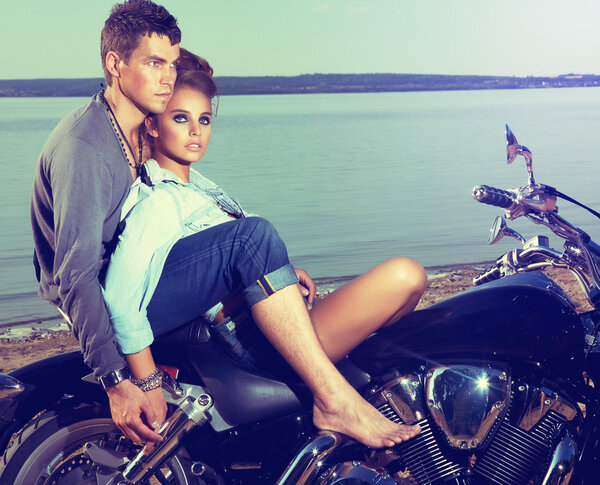 Romantic couple family resting on lake shore - motorbike