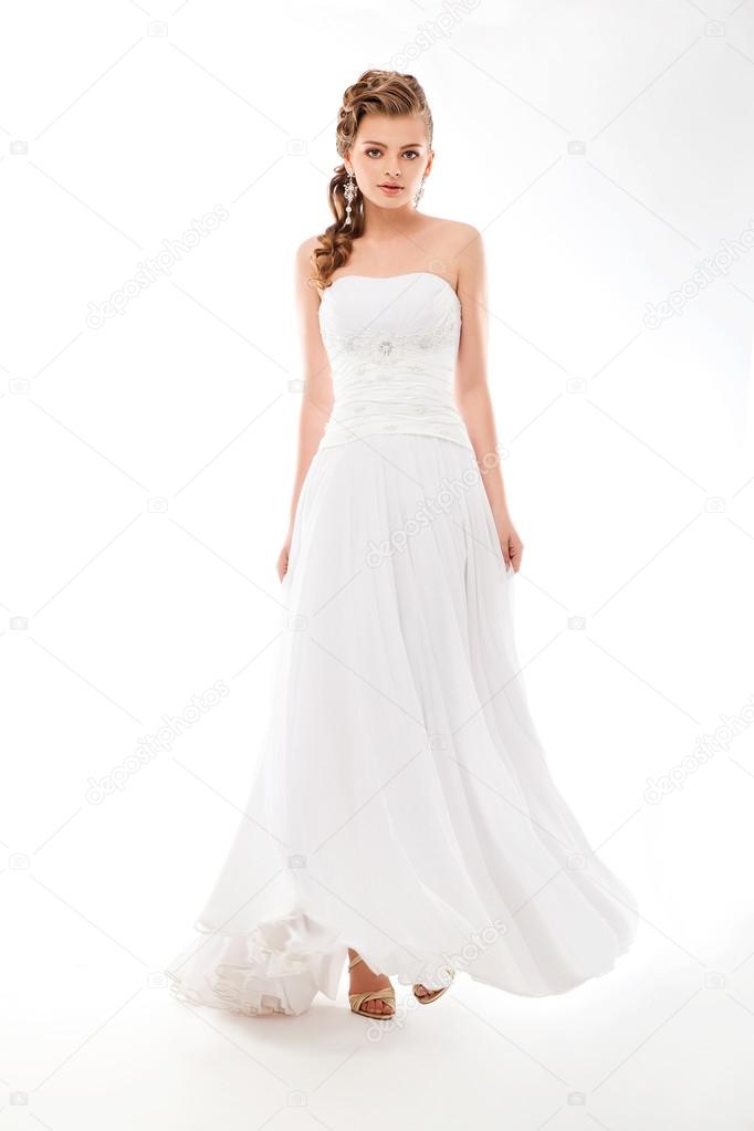 Beautiful woman in wedding dress over studio background