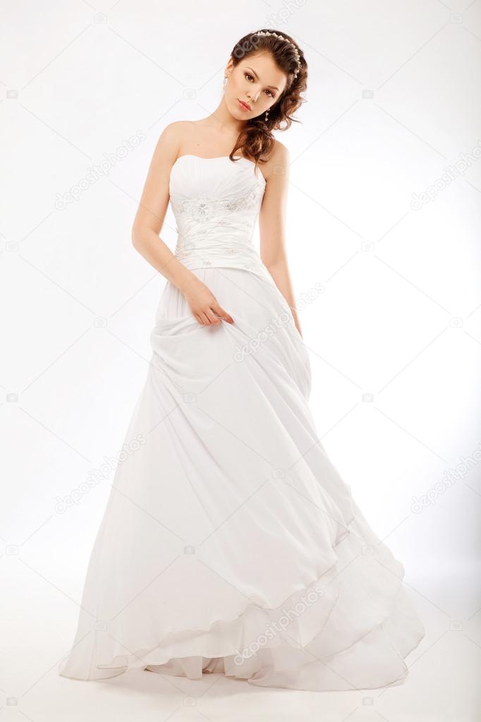 Beautiful bride in luxurious white wedding long dress posing