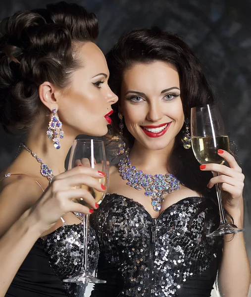 Weihnachten. Modefrauen mit Champagnergläsern lizenzfreie Stockfotos