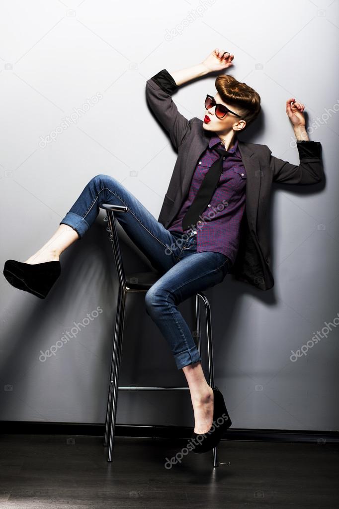 Pin-up girl in sunglasses sitting. American retro style