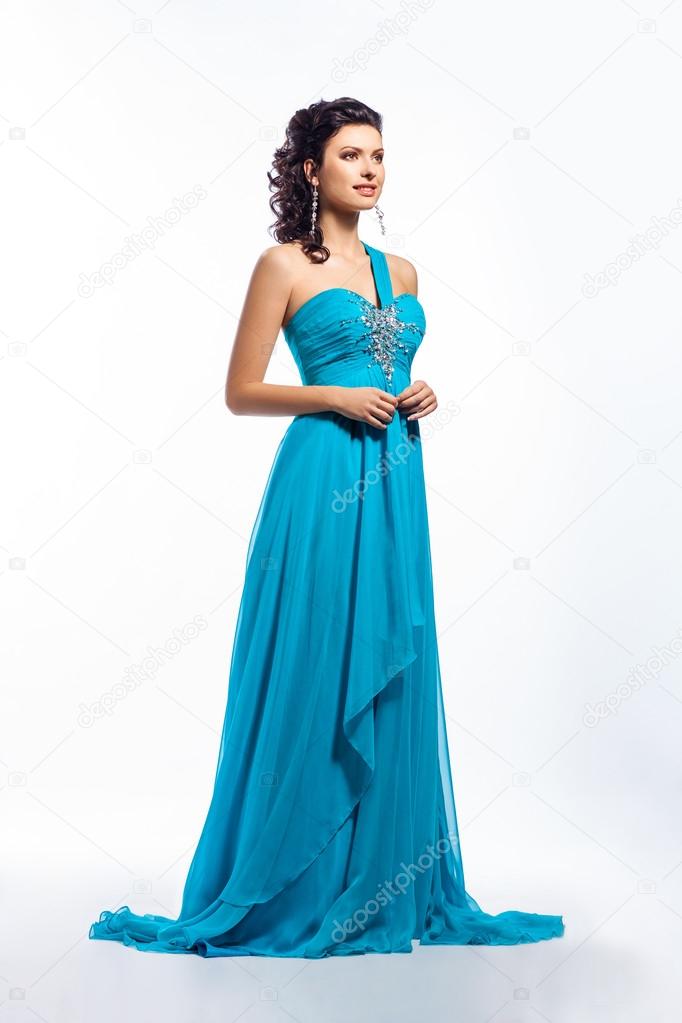 Elegant girl in contemporary blue dress over white background
