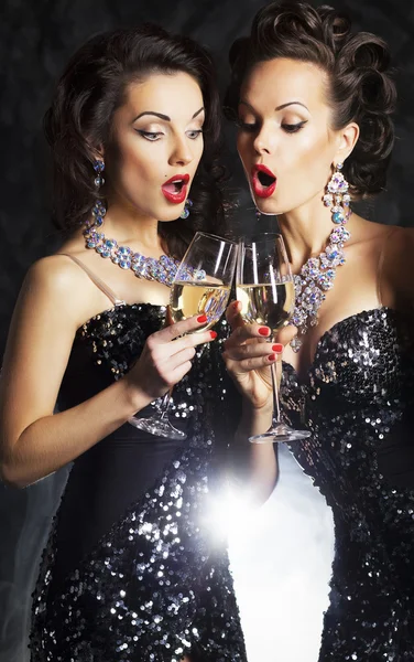 Deux belles femmes avec du champagne chantant des chansons de Noël — Photo