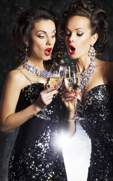Couple of cheerful women toasting at party with wineglasses celebrating