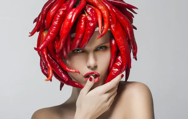 Módní trendy žena s červeným chilli jako čepice — Stock fotografie