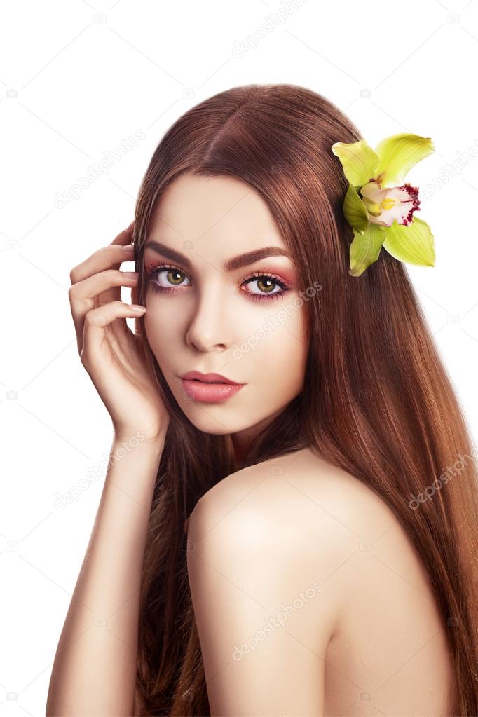 Beautiful Brunette Girl. Healthy Long Hair with Orchid Flower