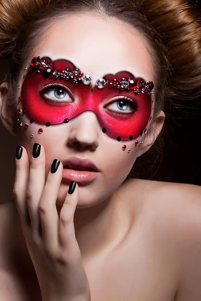 Cara pintada. Menina bonita em máscara de carnaval vermelho. Mascarada — Fotografia de Stock