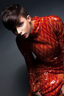 Uğur. Kırmızı elbise poz içinde şık genç kadın