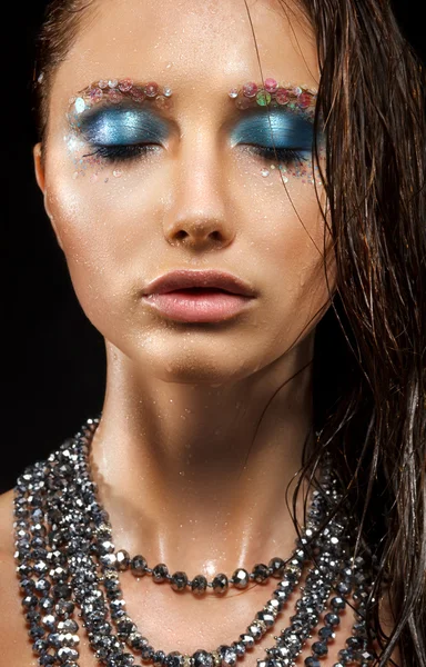 Affascinante donna bagnata viso - collana di perline, trucco blu brillante — Foto Stock