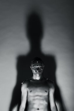 Gri kaplı dalgın adam ışıklar ve gölgeler. Fantezi ve gizem