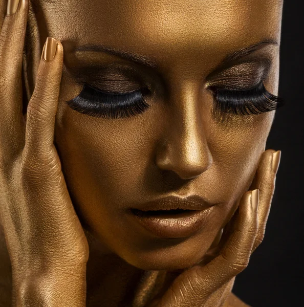 Gilt. Primo piano del volto di una donna d'oro. Trucco futuristico dorato. Pelle dipinta — Foto Stock