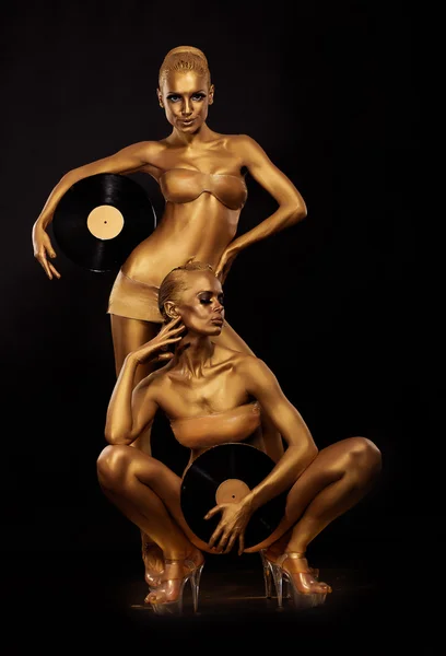 Guld bodyart. färg. gyllene kvinnor silhuetter med retro vinyl records över svart. Creative art concept — Stockfoto