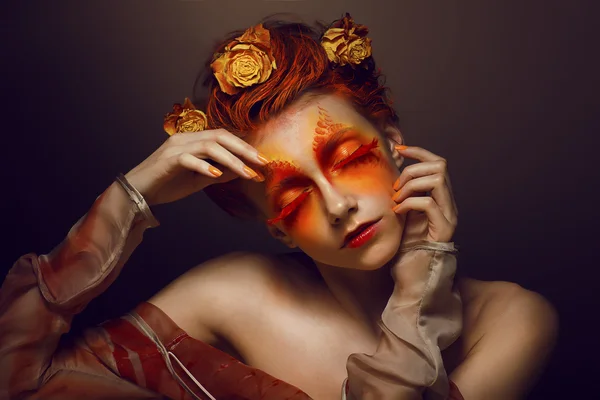 Bodyart. Imaginación. Mujer artística con rojo - Maquillaje de oro y flores. Colorear —  Fotos de Stock