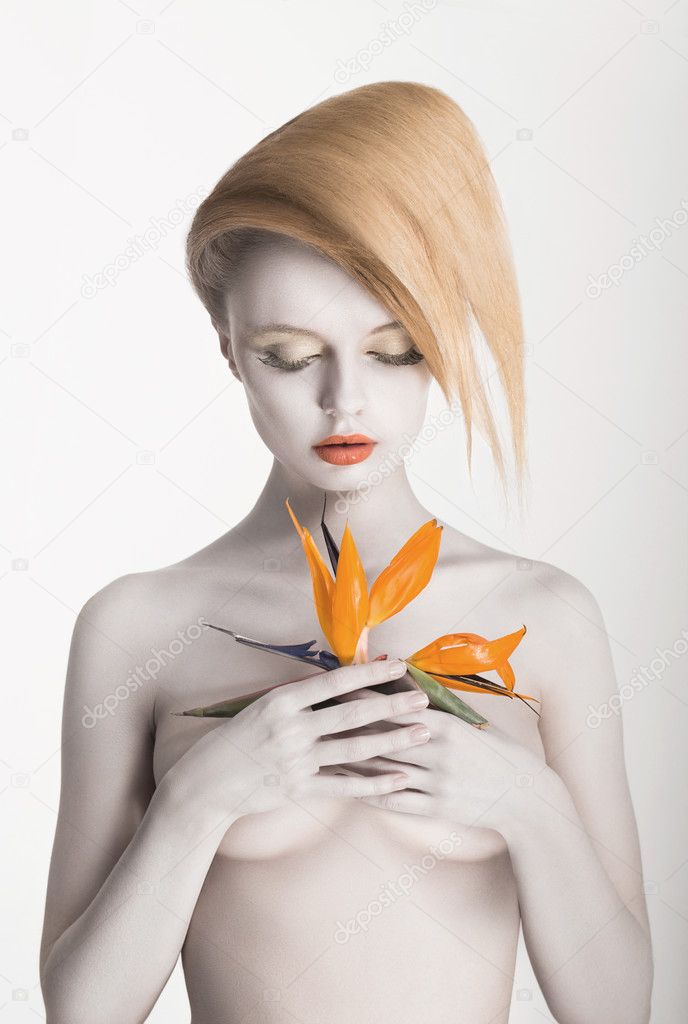 Bodypainting. Enigmatic Gorgeous Woman with Strelitzia flower in hands. Painted Skin